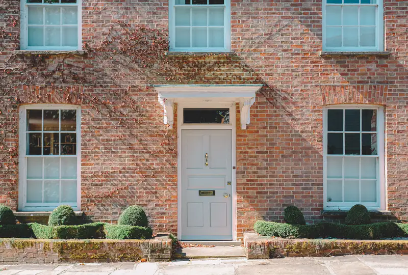Pale blue front door with a fanlight on a red-brick house, illustrating composite doors for homes in South Shields