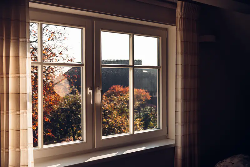 Flush Sash Windows in Newcastle upon Tyne White flush casement windows looking out onto an autumn garden, illustrating flush sash windows for homes in Newcastle upon Tyne