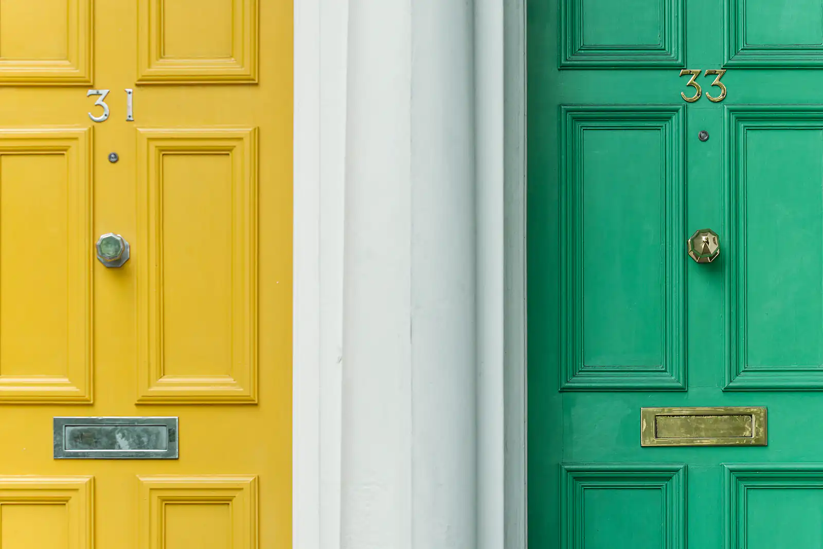 Yellow and green panelled front doors side by side, illustrating front and garden doors for homes in Newcastle upon Tyne