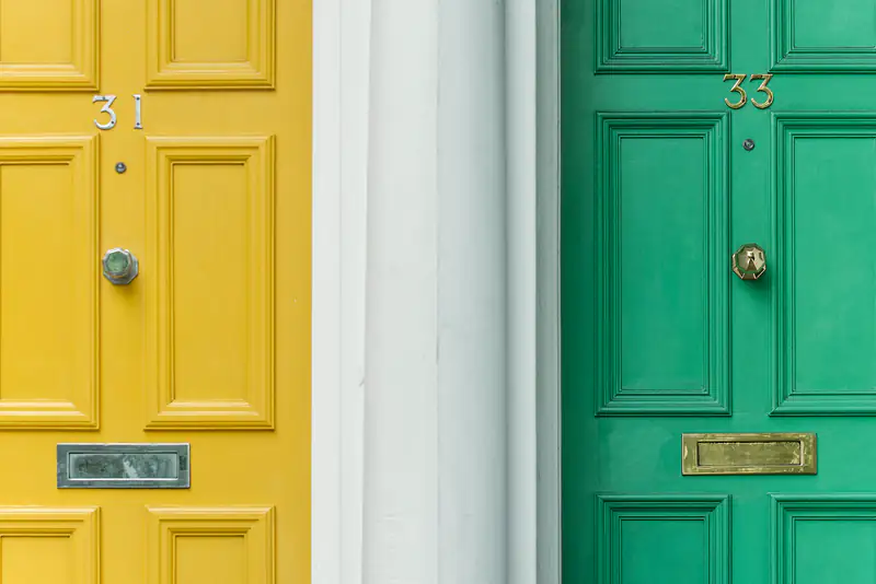 Yellow and green panelled front doors side by side, illustrating front and garden doors for homes in Newcastle upon Tyne