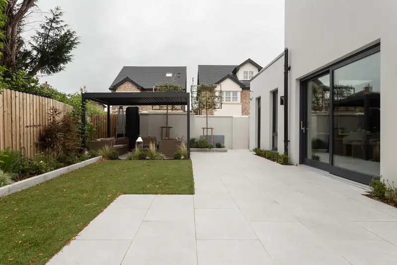 Replacement Conservatory Roofs in Cramlington Modern rear extension with a solid roof, large glazed doors and a patio garden, illustrating replacement conservatory roofs for homes in Cramlington