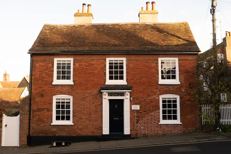 Sash Windows in Newcastle upon Tyne Red-brick period house with a white sliding sash window and a black front door, illustrating sash windows for homes in Newcastle upon Tyne
