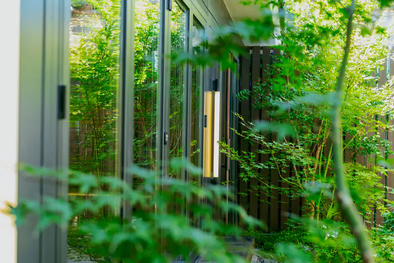 Green garden seen through a large glass door with a brass handle, illustrating sliding patio doors for homes in Newcastle upon Tyne