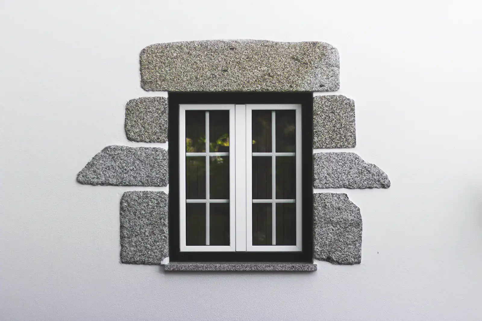 Small white casement window set in a stone surround, illustrating window & door repairs for homes in Newcastle upon Tyne