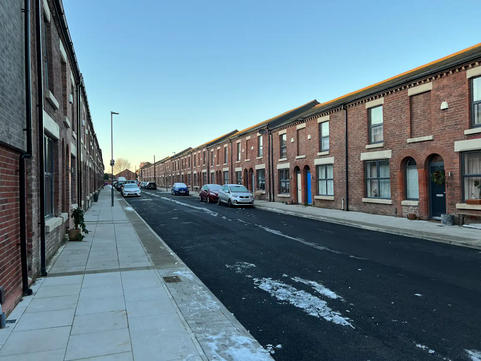 Street of red-brick terraced houses with parked cars, illustrating windows and doors for homes in Wallsend